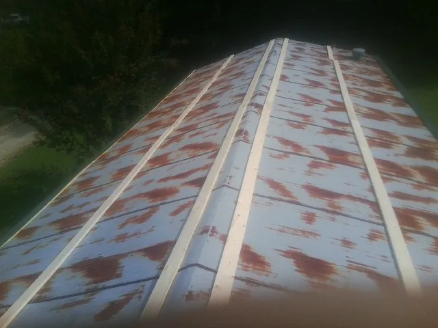 Rusted metal roof panels with new wood purlins before replacement — Storm Damage Roof Repair in Burkeville by Roofing Brothers